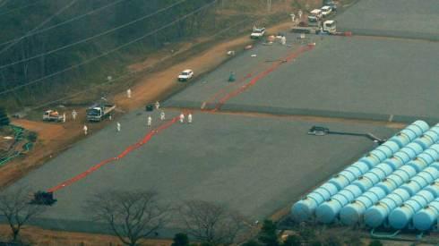 Where did it go?: Workers examine an underground tank Saturday that leaked 120 tons of highly radioactive water at the Fukushima No. 1 nuclear plant in the town of Okuma. KYODO