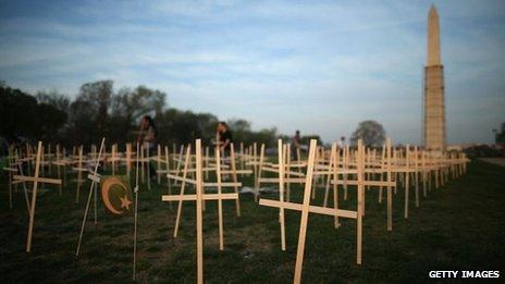 Volunteers place grave markers on the National Mall in Washington DC as over 3,300 crosses, stars of David, and other religious symbols are placed to remember those affected by gun violence 11 April 2013
