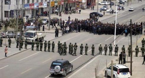 Chinese security personnel face off protesters on a street of Xilinhot in northern China's Inner Mongolia province. 