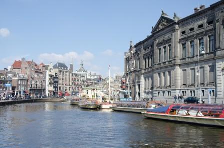 a canal with boats moored l in Amsterdam