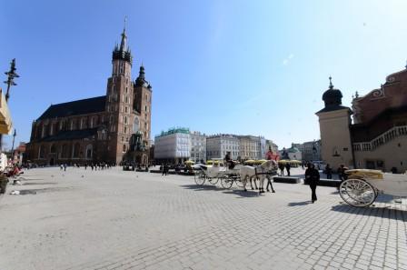 Main square in Krakow with horse drawn carts parked up