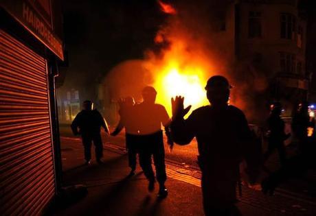 Image: Riot police charge past burning buildings in Croydon, south London