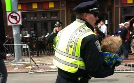 A police officer carries a child to safety after the Boston Marathon bombings