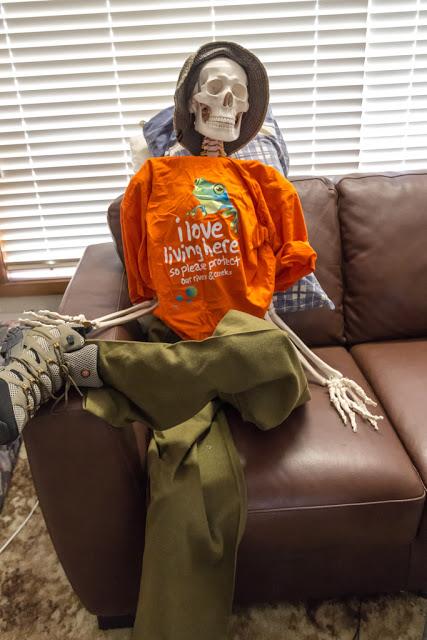 skeleton with clothes on sitting on couch