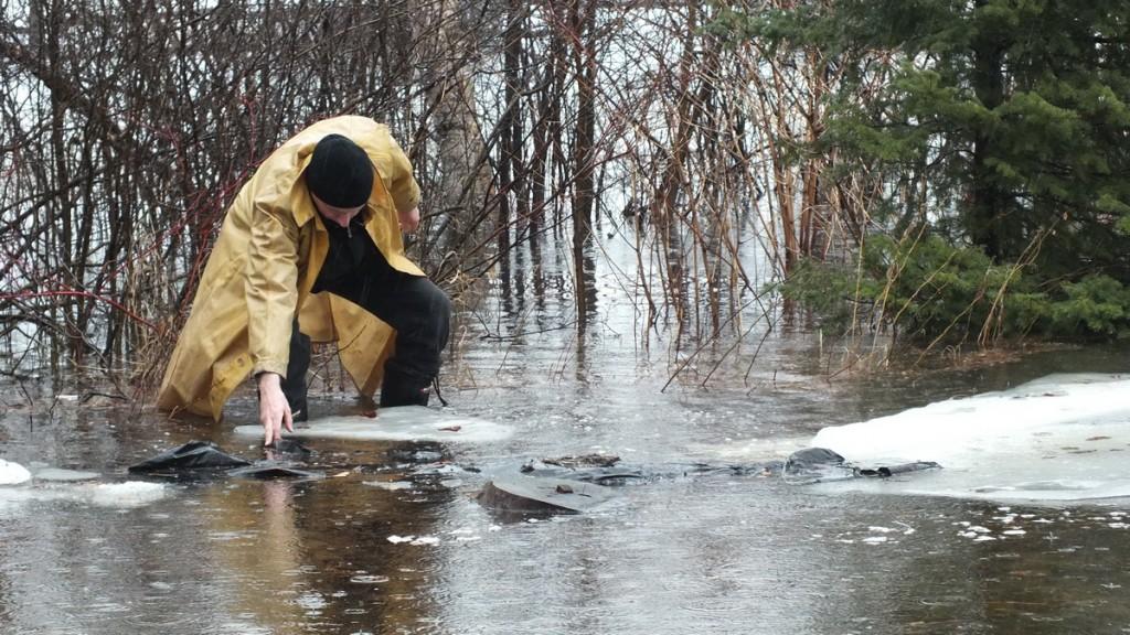 Oxtongue Lake flooding - Bob retrieves plastic sheet floating in flood waters- April 20 2013