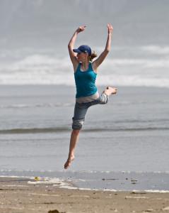 5 of 8 Girl dances at water's edge on Morro Strand State Beach