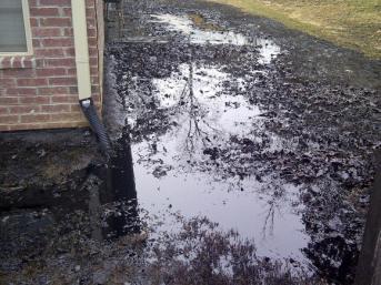 Spilt oil from Exxon pipeline runs between homes in North Woods Subdivision in Mayflower, Ark in early April. More oil from the same pipeline also spilled Tuesday in a yard in Missouri. (Reuters)