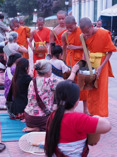 P42903431 托鉢の列が目に鮮やかなルアンパバーンのまち / Luang Prabang, hundreds of monks walk through the streets collecting alms.
