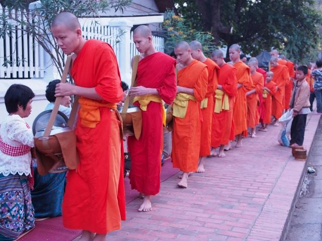 P42801621 托鉢の列が目に鮮やかなルアンパバーンのまち / Luang Prabang, hundreds of monks walk through the streets collecting alms.