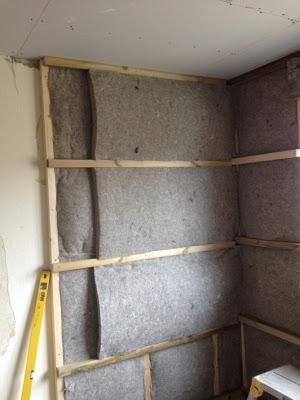 Second layer of sheepwool internal insulation being fitted to the wall