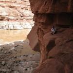 Watching the river flow past from a ledge inside a slot canyon.