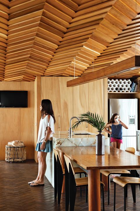 Modern kitchen with onyx kitchen island and wood slatted ceiling