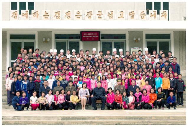 Kim Jong Un (1) and his wife Ri Sol Ju (2) pose for a commemorative photograph with campers, employees and officials at Mt. Myohyang Children's Camp on 19 May 2013 (Photo: Rodong Sinmun).