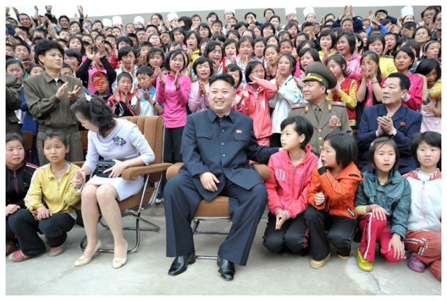 Kim Jong Un (1) and his wife Ri Sol Ju (2) interact with children campers during a commemorative photo session after KJU toured the Mt. Myohyang Children's Camp in North P'yo'ngan Province on 19 May 2013 (Photo: Rodong Sinmun)