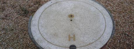 A manhole cover with a stylized hydrogen atom. The black plus in the center represents a proton and the yellow minus a negatively charged electron. (Credit: Flickr @ Joshua Kuhn http://www.flickr.com/photos/habitue01/)