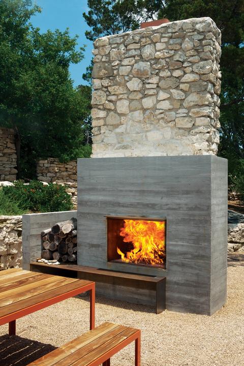 Modern outdoor fireplace area with wooden benches 