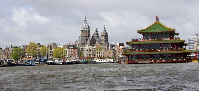 Town hall and Chinese center seen from a canal in Amsterdam.