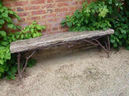 driftwood like garden bench with shapely iron branch like legs