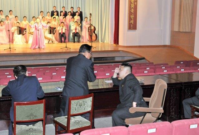 Kim Jong Un (R) smokes a cigarette and talks with a subordinate during a performance by the Ch'angso'ng County art propaganda squad at the county's cultural hall (Photo: Rodong Sinmun).