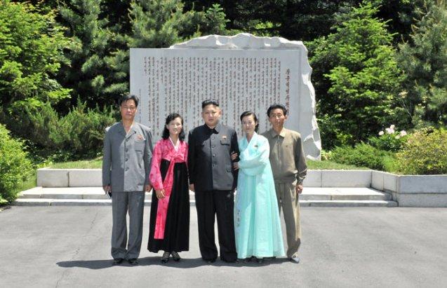 Kim Jong Un (C) poses for a commemorative photograph with museum employees in front of a revolutionary historical marker at Ch'angso'ng Revolutionary Site (Photo: Rodong Sinmun)