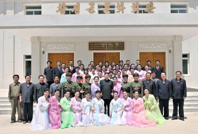 Kim Jong Un poses for a commemorative photographs with members of the Ch'angso'ng County art propaganda squad in front of the county cultural hall (Photo: Rodong Sinmun).