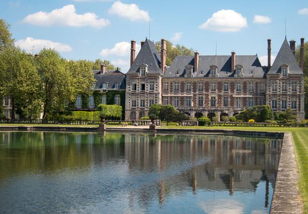 Photo of chateau with reflecting pool in foreground