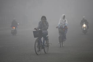 Residents of Sampit, Indonesia, bike through smog in Sept. 2012. (Photo: Reuters) 