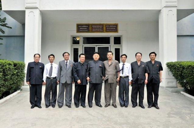 Kim Jong Un (C) poses for a commemorative photograph with personnel and managers of the Kanggye General Tractor Plant (Photo: Rodong Sinmun).
