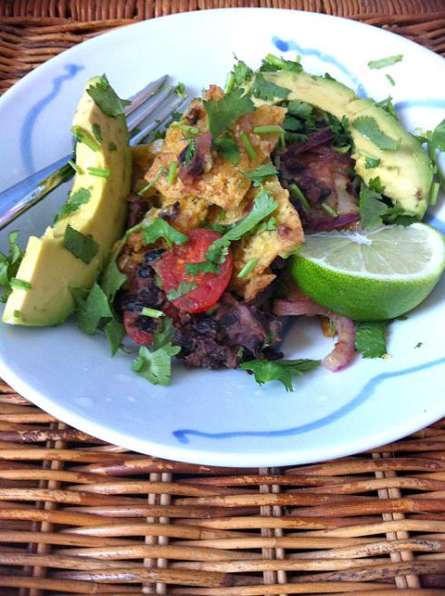 a plate of vegan chilaquiles with lime and cilantro