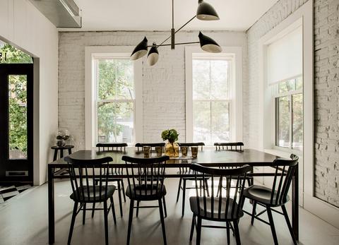 Modern dining area with black furniture and David Weeks pendant light