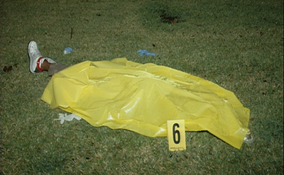 Crime scene photo of Trayvon's body covered with a yellow crime scene sheet. Nasty stuff.
