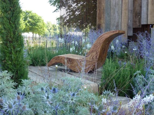 a modern chair sits in the center of the garden