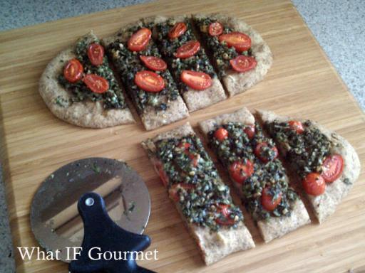 Broccoli rabe pesto and cherry tomatoes atop chickpea flatbread