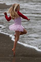 Cute Little Girl in Pink Dances on  Beach duri...