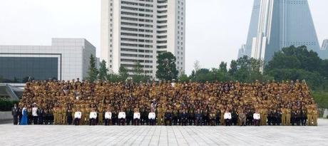 Kim Jong Un and senior DPRK officials poses for a commemorative photograph with veterans of the Fatherland Liberation War (Korean War) in Pyongyang on 30 July 2013.  Seen in the background are the Mirae Shop (L) an apartment building for senior DPRK Cabinet officials (C) and the Ryugyo'ng Hotel (R) (Photo: Rodong Sinmun).