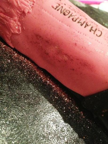 champagne bottle cake with edible ink written label and pink edible glitter