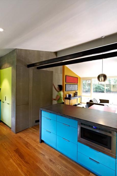 Modern kitchen renovation with dark concrete counter and blue cabinets