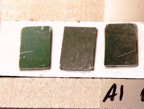 Black metal samples with different nanostructures thickness and coated with aluminum laying over a high reflective flat aluminum surface. (Credit: Lawrence Livermore National Laboratory)