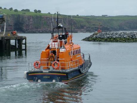 lifeboat leaves harbor from dunmore east in county waterford - ireland