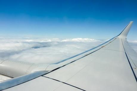 aircraft wing flying above clouds