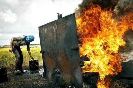 A fire rages under the boiler filled with crude oil. The intense heat vapourizes the oil, after which the vapor can be cooled back down to diesel or petrol. [Jeffry Ruigendijk/Transterra Media]