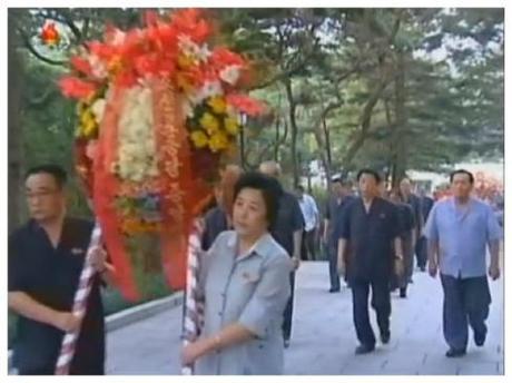 Han Kwang Bok (R), Director of the KWP Science Education Department carries a floral wreath on behalf of the Party Central Committee to the grave of Kim Po Hyon in Pyongyang on 19 August 2013 (Photo: KCTV screengrab).