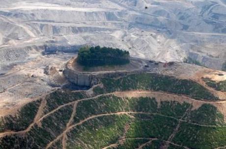 Ohio Valley Environmental Coalition, Maria Gunnoe/Associated Press - In this June 2010 aerial photo released Thursday, Aug. 29, 2013 by Ohio Valley Environmental Coalition, mining equipment is seen on a mountain top near a cemetery is inside the forested area on that tiny knob of land in the middle of the mine complex. Six southern West Virginia residents are suing Virginia-based Alpha Natural Resources over damage to a family 