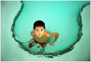 A boy in a children's swimming pool.
