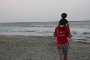 father and son walking on beach