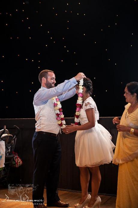 Groom puts floral wreathe on Bride