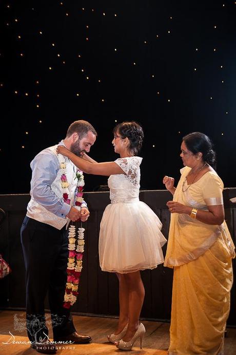 Bride puts floral wreathe on groom