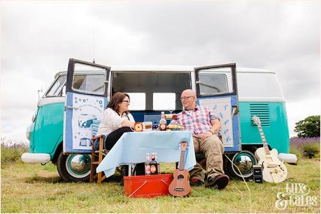 Rocker couple have a picnic in front of their turquoise VW camper van in Mayfield Lavender field 