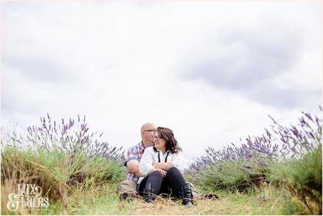 Alterntiative rocker couple have engagement session in lavender field sitting down and cuddling 