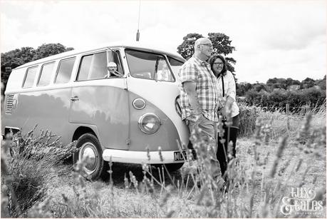 Couple cuddle inf ront of vintage VW camper van 